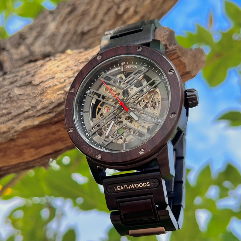 Side angle view of wooden automatic watch showing thick case and stainless steel band