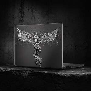 May include: A dark gray laptop featuring a white line art illustration of a winged figure with arms outstretched. The figure is depicted with detailed feathers on the wings and a flowing cloth wrapped around the lower body, set against a dark background.