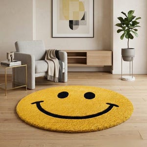 Pu&ograve; includere: Un tappeto rotondo giallo con un grande design a faccina sorridente nera. Il tappeto &egrave; posto su un pavimento in legno in una stanza con una poltrona grigia, un tavolino e una pianta in vaso. Il design del tappeto &egrave; semplice e audace.