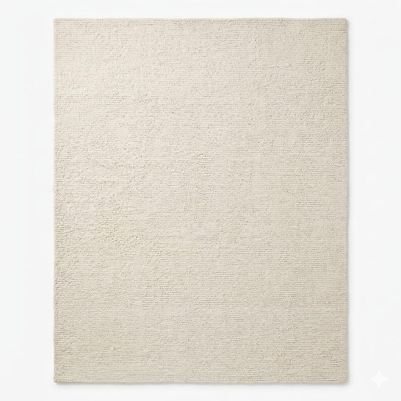 May include: A rectangular, off-white rug with a textured surface. The rug has a simple, neutral design, suitable for various interior styles. The rug's color is a light cream, providing a soft and inviting look.