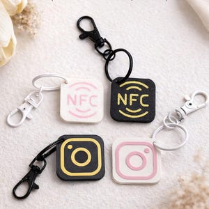 May include: Keychains with NFC tags in black, white, and gold. The keychains display the Instagram and NFC logos. The image includes the text "NFC TAG KEYCHAIN" and "Tap and Connect with Just a Tap".