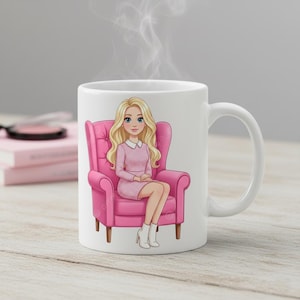 May include: White ceramic mug featuring a cartoon illustration of a woman with blonde hair sitting in a pink armchair. The woman is wearing a pink dress and white boots. Steam rises from the top of the mug.