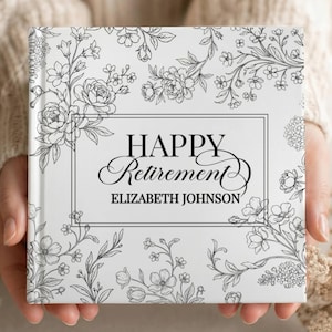 May include: A square book with a white cover featuring black line art of various flowers and foliage. Centered in a rectangular frame is the text "HAPPY RETIREMENT" in a serif font, followed by the name "ELIZABETH JOHNSON" in a sans-serif font.