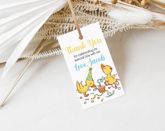Può includere: Grazie per aver celebrato il mio giorno speciale con me, Con affetto, Jacob. Un biglietto bianco con testo giallo e blu e un'immagine di cartone animato di due paperi gialli con cappelli da festa e coriandoli.