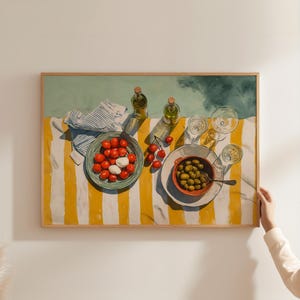 May include: A framed still life painting depicts a picnic scene. A yellow and white striped tablecloth holds a plate of tomatoes and mozzarella, a bowl of olives, two bottles, and glasses. A striped cloth and cherries are also present.