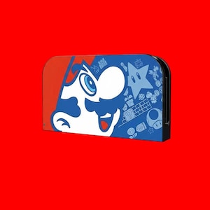 Peut inclure: Une coque de Nintendo Switch bleue et rouge avec un graphisme du visage de Mario et d'autres éléments emblématiques de la série de jeux Super Mario Bros. L'étui a une bordure noire et est posé sur un fond rouge.