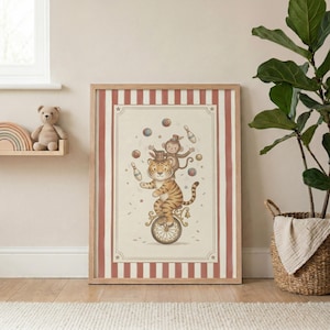 May include: A framed illustration depicts a tiger riding a unicycle, with a monkey on its back juggling balls and bowling pins. The artwork has a vintage circus theme, with a cream-colored background and a red and white striped border. The tiger is orange with black stripes.