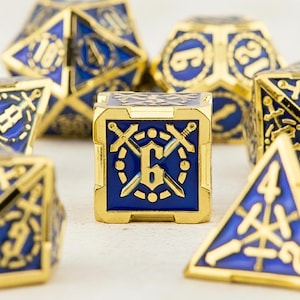 May include: A set of polyhedral dice with a gold finish and blue enamel. The dice feature various geometric shapes, including a cube with the number 6 and crossed swords. Other dice show numbers and symbols.