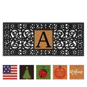 May include: Black rectangular doormat with an ornate border design. The center features a tan square with the letter "A" in black. Below are small images of an American flag, a Christmas tree, a ladybug, a jack-o'-lantern, and the word "Welcome".