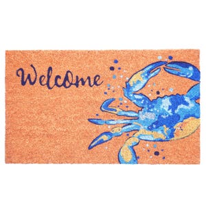 Puede incluir: Una alfombra rectangular con fondo beige. La palabra "Welcome" está escrita en escritura azul marino en el lado izquierdo. Un diseño de cangrejo azul y dorado está en el lado derecho, con motas azules esparcidas alrededor del cangrejo.