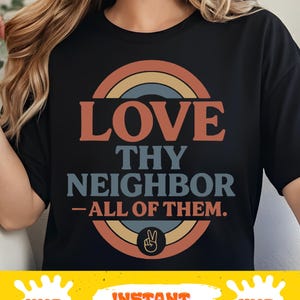 May include: Black t-shirt with a retro design. The design features the words "LOVE THY NEIGHBOR - ALL OF THEM" in orange and blue text, with a peace sign. The design is set within a rainbow-coloured circle.