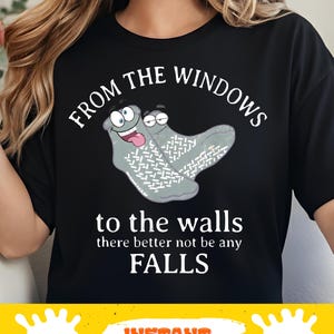 May include: Black t-shirt with the text "FROM THE WINDOWS to the walls there better not be any FALLS". The shirt features a cartoon graphic of two gray socks with faces.