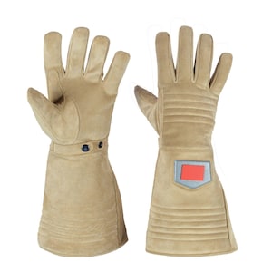 May include: A pair of tan suede gloves with long cuffs. The gloves have a reinforced palm and fingers, with a strap and two buttons at the wrist. The cuffs feature horizontal stitched lines and a small patch with a red rectangle.