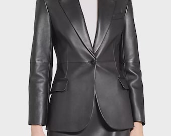 May include: A black leather blazer with a single-button closure, notched lapels, and two front pockets. The blazer is paired with a matching black leather skirt. The outfit is a classic, tailored style.