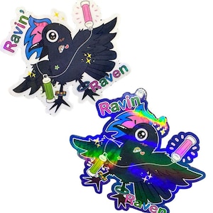 May include: Two vinyl stickers featuring a stylized black raven with colorful accents. The stickers have the text "Ravin' Raven Vinyl Stickers" at the top. The raven design includes a pink and green glow stick and the word "Ravin'" and "Raven".