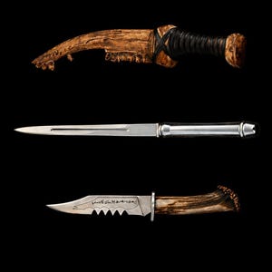 May include: Three knives with different designs against a black background. The top knife has a curved, wooden blade and handle with a black wrapped grip. The middle knife is a long, slender blade with a silver handle. The bottom knife has a serrated blade and a wooden handle.