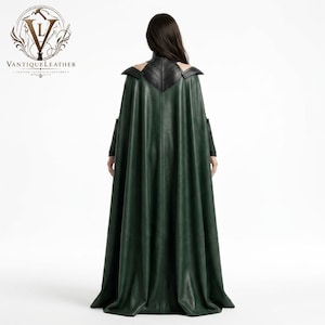 May include: A floor-length dark green leather cape featuring a structured black leather collar and shoulder panels. The garment displays a V-shaped back yoke design with visible stitching. The VANTIQUELEATHER logo is visible in the top left corner.