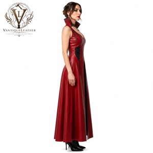 May include: A floor-length sleeveless dress made of red leather featuring a high collar, a deep V-neckline, and black lace-up side panels. The garment has a fitted bodice that transitions into a flared skirt, with black trim along the edges.