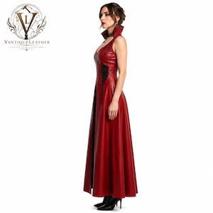 May include: A floor-length sleeveless red leather dress featuring a high collar, black lace-up side detailing, and a V-neckline. The garment is fitted through the bodice and flares into a full skirt, showcasing a smooth texture and clean lines.