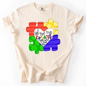 May include: A set of three ceramic mugs with a speckled, cream-colored glaze. Each mug features a different hand-painted design: a blue and green leaf, a yellow flower, and a red berry. The mugs have a simple, modern design.