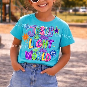 May include: A bright turquoise short-sleeve t-shirt featuring the colorful text "JESUS is the LIGHT of the WORLD" and "JOHN 8:12" in a bold, multi-colored font. The design is accented with various star shapes in orange, blue, and purple colors.