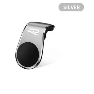 以下が含まれることがあります： 黒い円形パッドが付いたシルバーのカーフォンマウント。マウントは湾曲したデザインで、小さなロゴが付いています。「SILVER」という単語が、マウントの上にある灰色の長方形に表示されています。