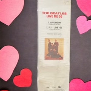 May include: A vintage vinyl record album cover featuring The Beatles. The album title is "Love Me Do" and the album cover features a black and white photo of the band members.