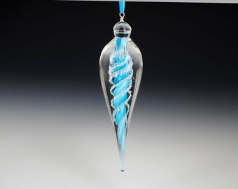 May include: A clear glass bauble with a swirling blue glass design inside. The bauble is teardrop shaped and has a silver cap at the top.