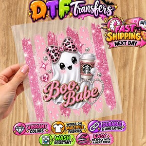 Puede incluir: Una hoja de transferencia DTF con un fantasma blanco con un lazo de estampado de leopardo, sosteniendo una taza de café, con el texto "Boo, Babe" en rosa. El diseño incluye pinceladas de purpurina rosa, estrellas brillantes y corazones.