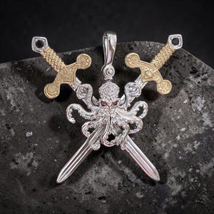 May include: A silver-toned pendant featuring a central octopus figure with small red eyes, positioned in front of two crossed swords. The swords have gold-toned textured hilts and silver-toned blades, with a small black stone set at each pommel.