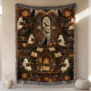 May include: A woven throw blanket featuring a detailed Halloween scene with ghosts reading books in a library, black cats, pumpkins, a fireplace, and autumn foliage. The design includes bookshelves, hanging lanterns, and flying bats in a dark colour palette.