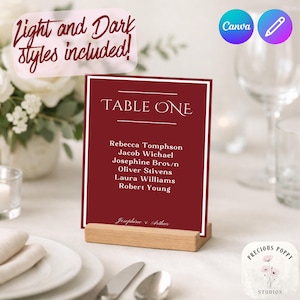 May include: A burgundy table card with white border and text, reading "TABLE ONE" and guest names. The card is held in a wooden holder. Text at the top reads "Light and Dark styles included!"