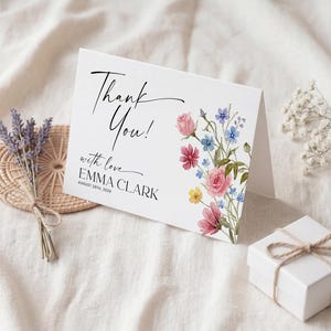 Collection of matching baby shower stationery designs including an invitation, diaper raffle ticket, books for baby card, and thank you note, all featuring a watercolor wildflower theme.