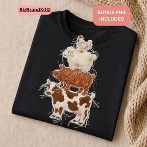 Könnte beinhalten: Schwarzes T-Shirt mit einem gestickten Design von Bauernhoftieren: einer Kuh, einem Schwein, einem Schaf und einem Huhn, die übereinander gestapelt sind. Die Kuh ist braun und weiß, das Schwein ist braun mit floralem Muster.