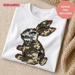 May include: White t-shirt featuring a camouflage bunny design. The bunny is made of various shades of green, brown, and gray, with a distressed, frayed edge. The shirt has a round neckline. A pink circle with the text "BONUS PNG INCLUDED" is in the upper right corner.