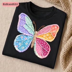 May include: Black long-sleeve shirt featuring a colorful butterfly applique. The butterfly design incorporates various patterns and colors, including blue, purple, pink, and orange. The shirt has a round neckline and is made of a soft material.