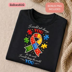 May include: Black t-shirt featuring a colourful puzzle ribbon design and the text "I would not change YOU, I would change the world for YOU." The design includes puzzle pieces in red, green, blue, and yellow.