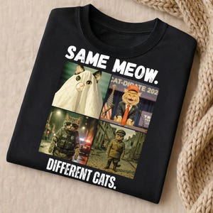 May include: Black long-sleeved shirt with the text "SAME MEOW. DIFFERENT CATS." and four images of cats in costumes. One cat is dressed as a ghost, another as a politician, and two others in military uniforms.