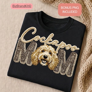 Puede incluir: Camiseta negra de cuello redondo con el texto "Cockapoo Mom" en una fuente marrón claro texturizada. Las letras "M" son de un marrón más oscuro. La imagen presenta una cara de perro Cockapoo sonriente en el centro.