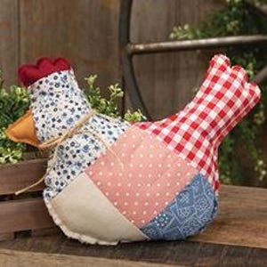 May include: A patchwork fabric chicken with a red comb and beak. The chicken's body is made of various patterned fabrics, including red and white gingham, blue floral, and pink polka dots. A twine bow is tied around the neck.