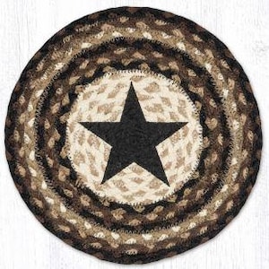 May include: Round braided rug with a star design. The rug features concentric circles of brown, tan, and black. A large black star is centered on a tan background. The rug is made of woven material.