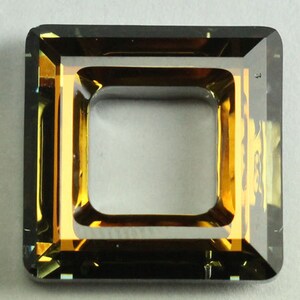 May include: A square-shaped, clear glass frame with a gold-colored border. The frame has a square opening in the center.