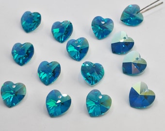 May include: A collection of heart-shaped crystal beads in shades of teal and blue. Each bead has a faceted surface, catching the light and creating a sparkling effect. Some beads have a hole for stringing. Ideal for jewelry making.