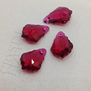 May include: Four faceted, teardrop-shaped, ruby-red crystal pendants. Each pendant has a small hole at the top for stringing. The crystals are highly reflective, catching and refracting light.