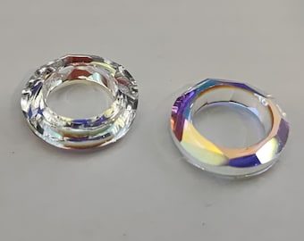 Könnte beinhalten: Zwei klare Kristallringe mit schillernden Regenbogenfacetten. Die Ringe haben einen Durchmesser von etwa 2,5 cm und ein Loch in der Mitte.