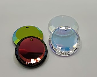 Puede incluir: Surtido de adornos redondos de vidrio iridiscente con un agujero en la parte superior para colgar. Los adornos son en tonos de verde, azul y rojo.