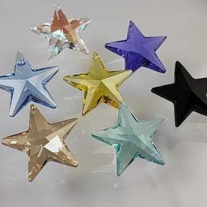 May include: Seven crystal star shaped pendants in various colours, including clear, blue, gold, black, and purple.