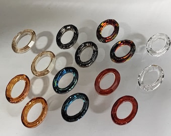 Peut inclure: Assortiment d'anneaux en verre de forme ovale dans différentes couleurs, notamment transparent, marron, rouge, bleu et noir. Les anneaux mesurent environ 2,5 cm de diamètre.