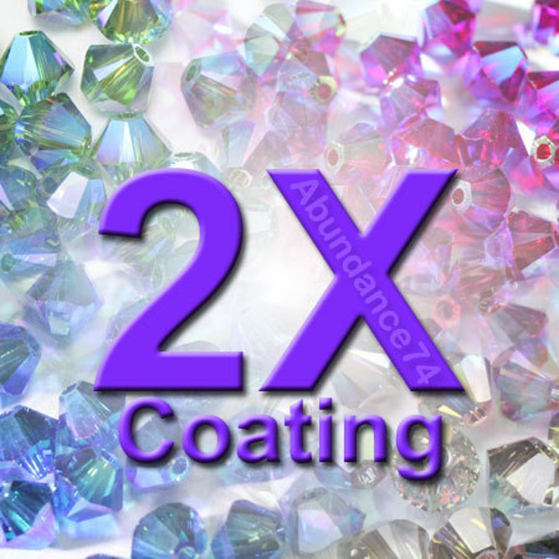 Op de afbeelding: Paarse, iriserende glazen kralen met een 2X-coatinglabel. Het label heeft de tekst "Abundance74" en "2X Coating".