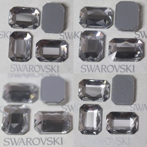 Op de afbeelding: Assortiment van heldere, rechthoekige, gefacetteerde strasssteentjes met het woord "SWAROVSKI" gedrukt op een witte achtergrond.